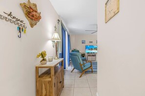 Een woonkamer met een televisie, een houten salontafel en een blauwe fauteuil.