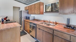 Une cuisine moderne avec des meubles en bois, des appareils électroménagers en acier inoxydable et une grande fenêtre.