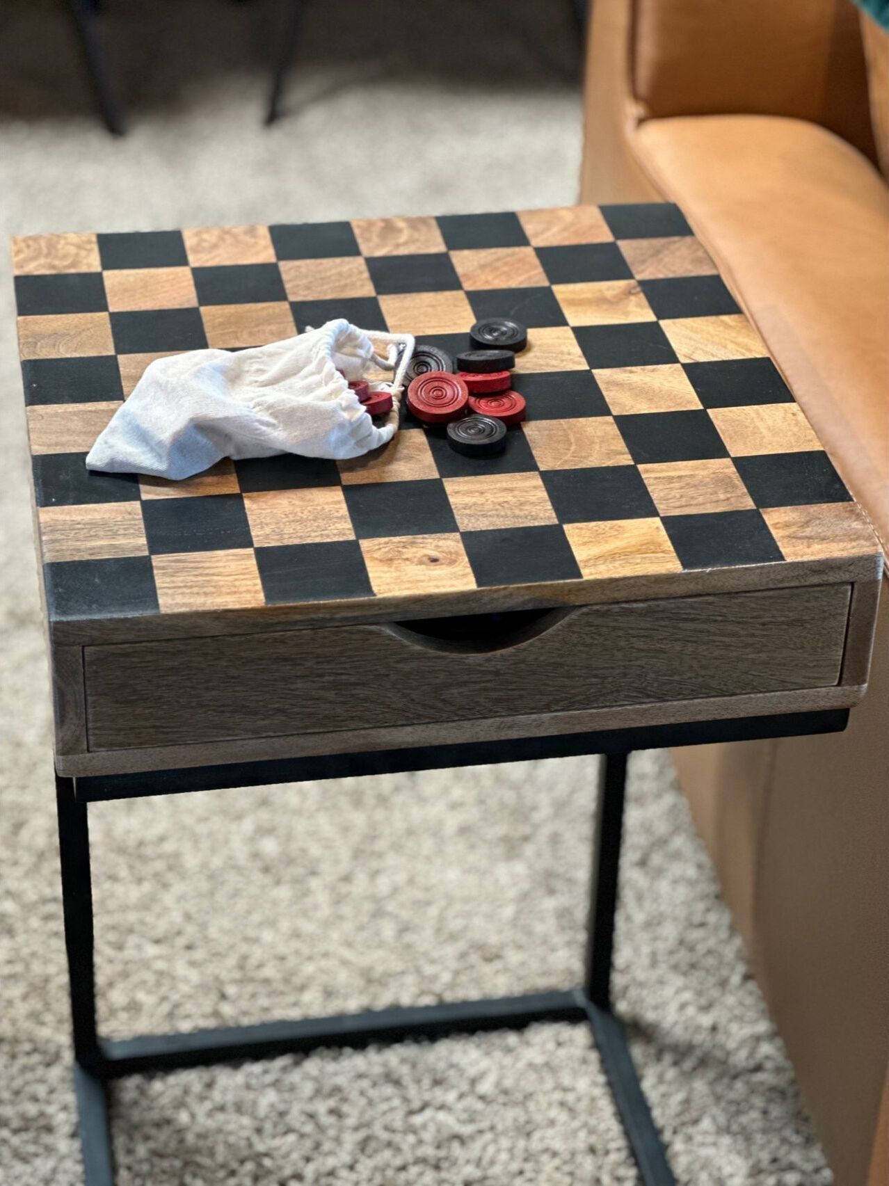Ein kleiner Holztisch mit kariertem Untergrund, einer weißen Tischdecke und Pokerchips.