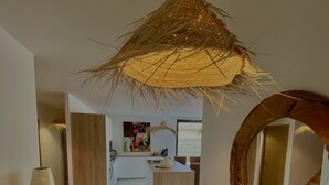 Une cuisine moderne avec des armoires blanches, un îlot central en bois et un luminaire suspendu.