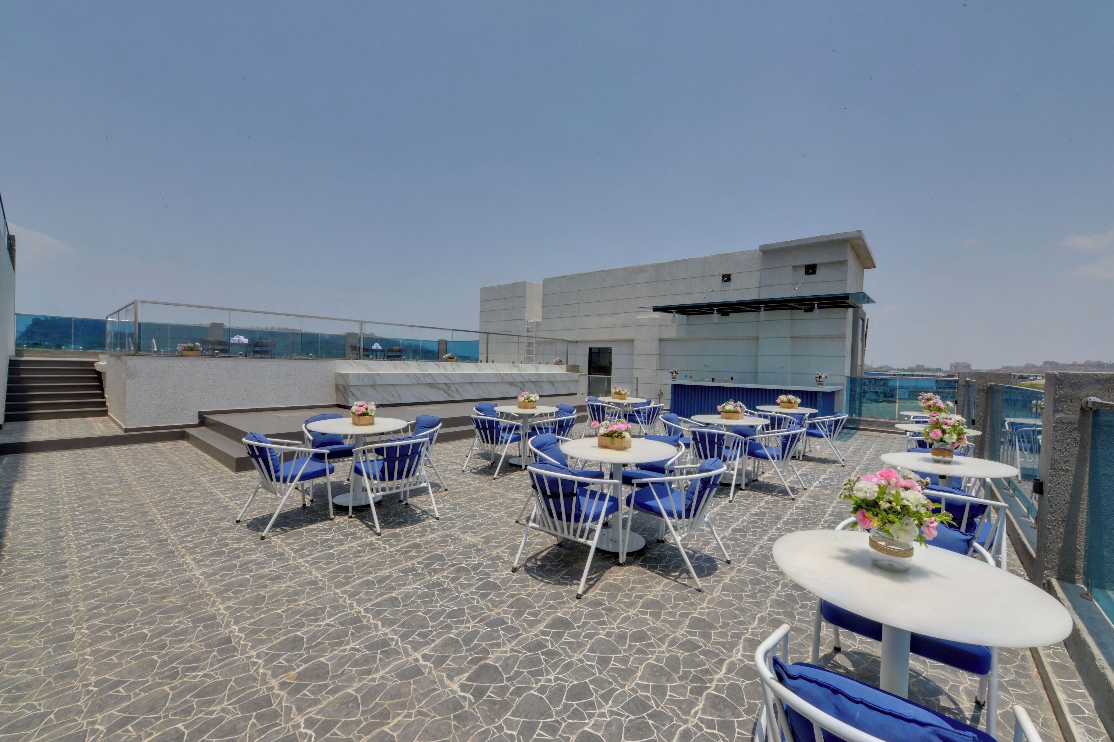 A rooftop terrace with outdoor seating and a view of the city.