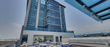 Terraza en la azotea con mobiliario exterior y vistas a un edificio moderno.