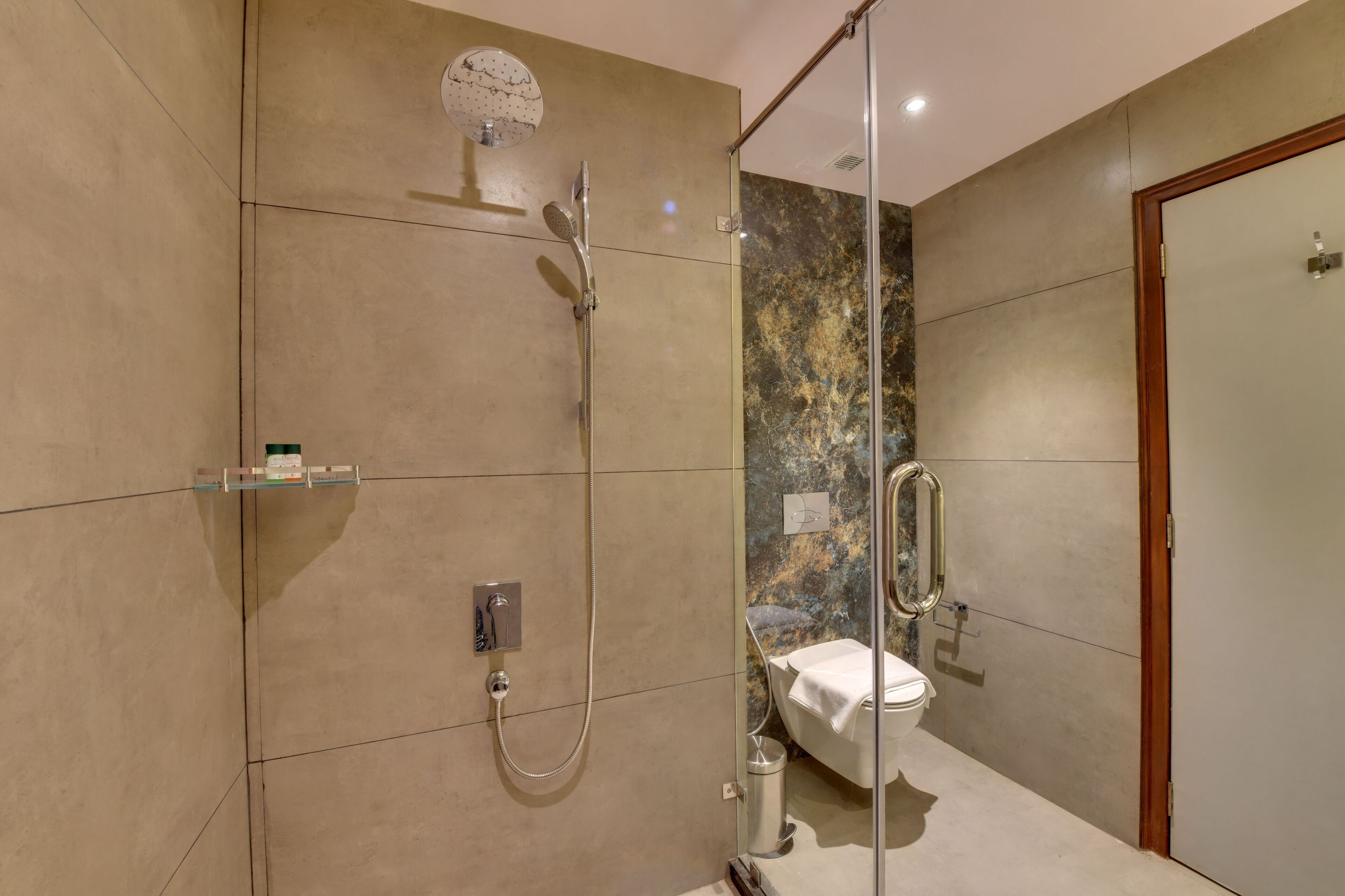 Un bagno moderno con doccia vetrata, un WC e un mobile vanitario con specchio.