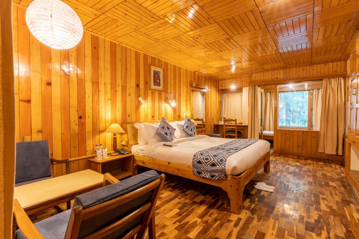 Una habitación de cabaña de madera con una cama, un escritorio y una silla.