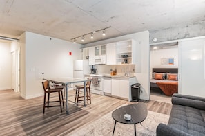 A modern apartment with a kitchen, dining area, and living room.