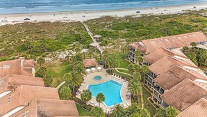 An aerial view of a resort with a swimming pool surrounded by palm trees, a beach, and a boardwalk. - 3 bedroom Ocean Front with amazing ocean views! (Saint Augustine)