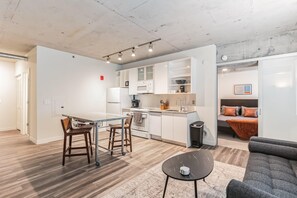 Un appartement moderne comprenant une cuisine, un coin repas et un salon.
