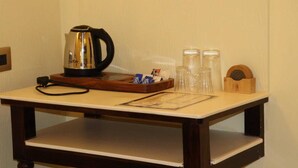 A hotel room with a wooden table, a kettle, salt and pepper shakers, and a small wooden box. - Satshree Kothi (Varanasi)