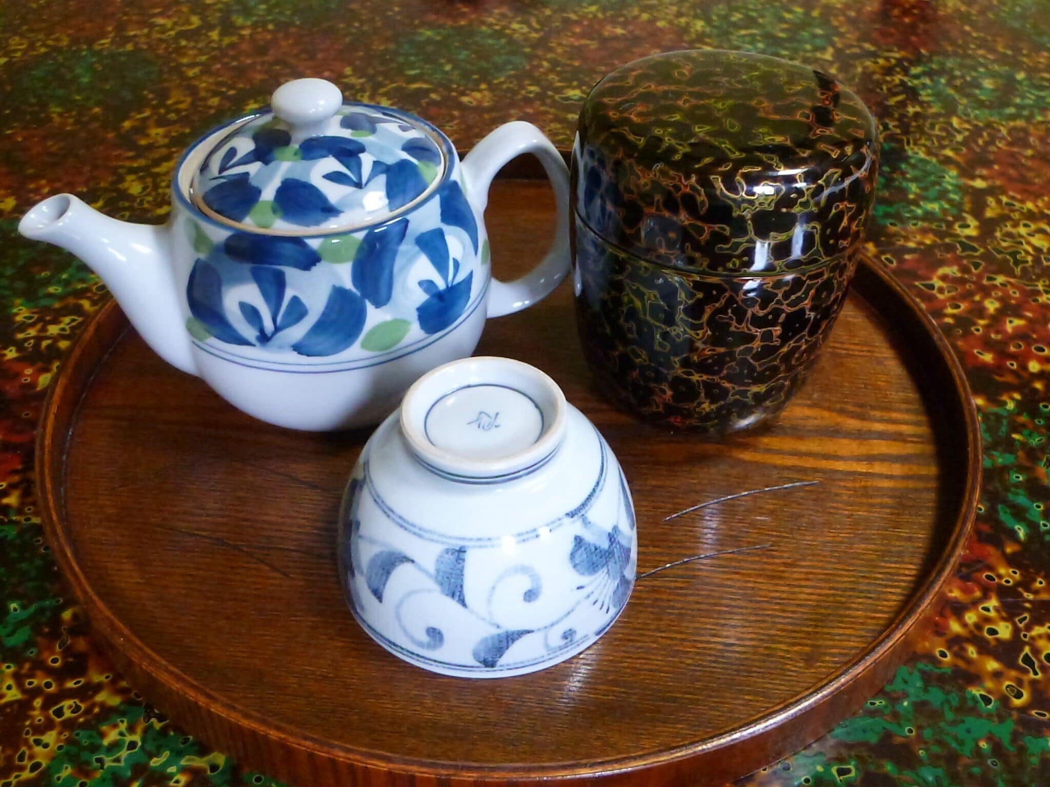 A tray with a teapot, a cup, and a small container.