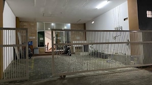 A gated entrance to a building with a tiled floor and a staircase leading to an upper level. - Bima Guest House (Malang)