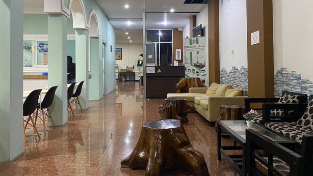 A hotel lobby with a reception desk, seating area, and a reception counter. - Bima Guest House (Malang)