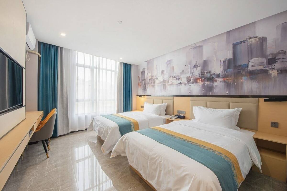Habitación de hotel con dos camas, un escritorio y un cuadro abstracto grande en la pared.