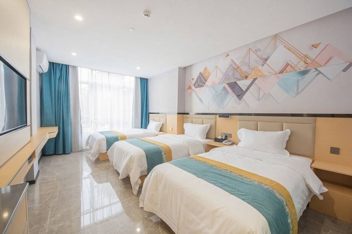 Habitación de hotel con dos camas, un televisor y una gran obra de arte abstracta en la pared.