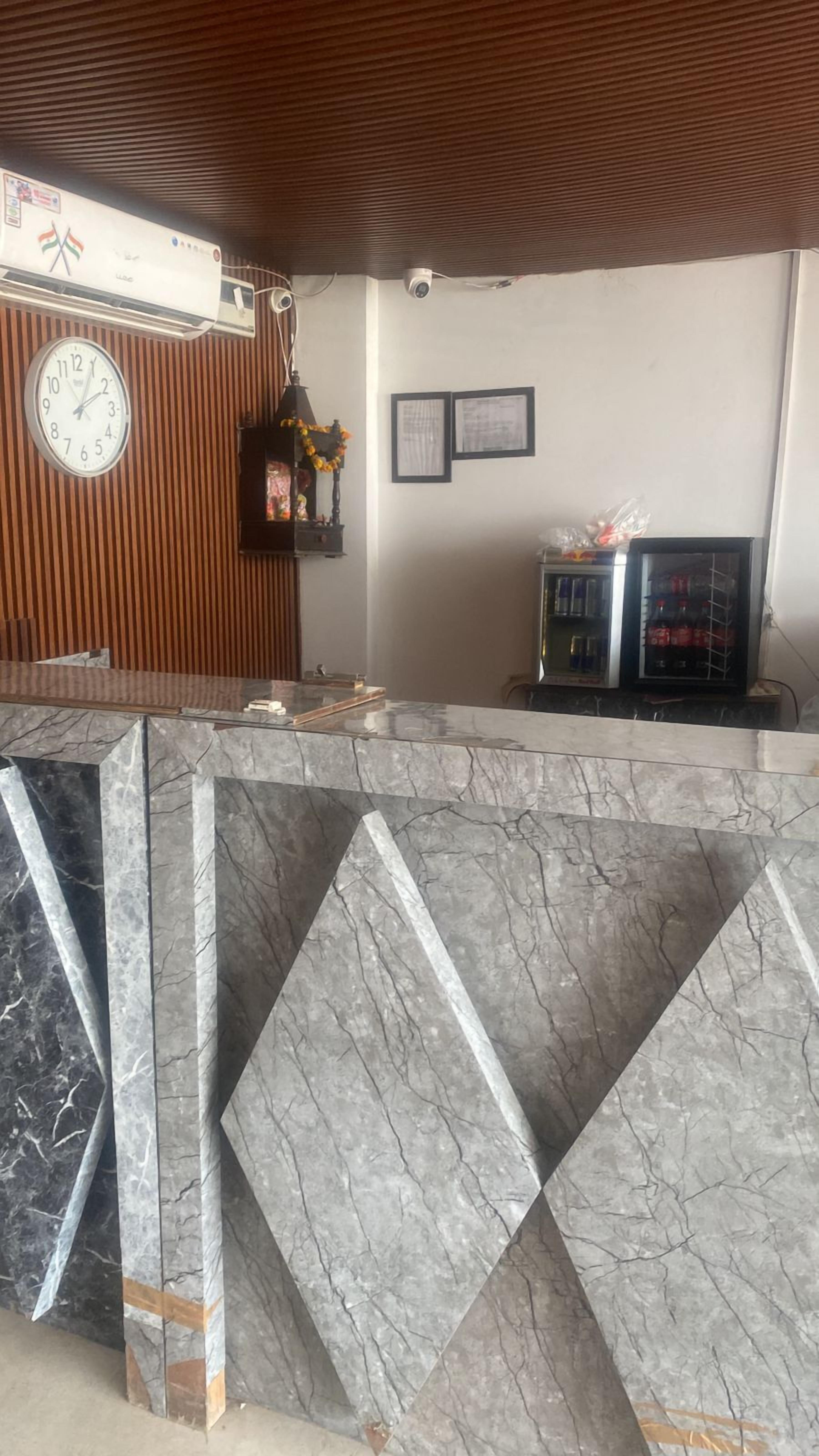 A reception desk with a marble counter, a clock, framed certificates, and a security camera.