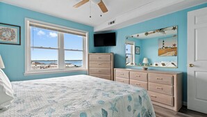 Un dormitorio con cama, cómoda y televisor.