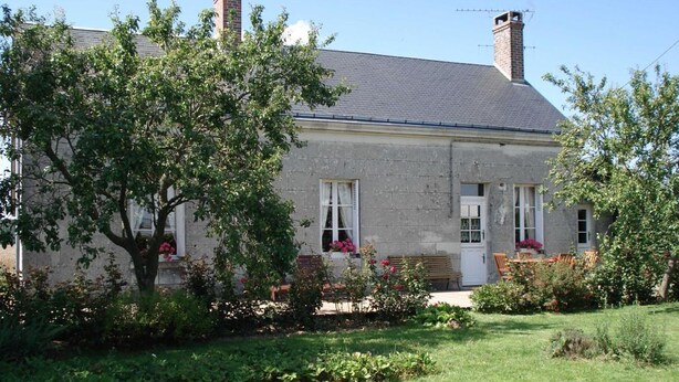 A stone house with a chimney, a garden with flowers, and a bench. - Restored Country House with WIFI and Fireplaces (Prunay-Cassereau)