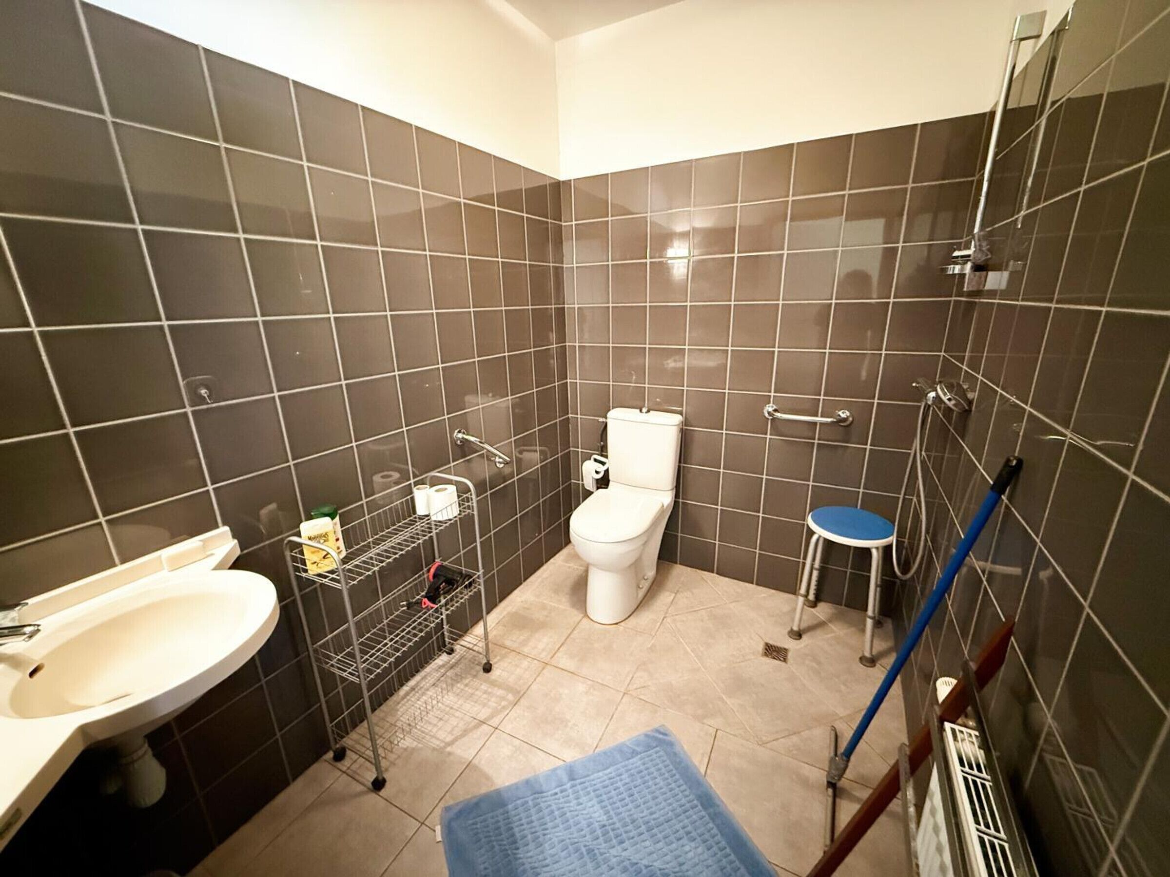 A bathroom with a toilet, sink, and shower area.
