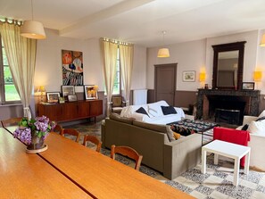 Una sala de estar acogedora con un sofá, una mesa de comedor y una chimenea.