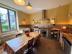 Una cocina compacta con una mesa de comedor, estufa y fregadero.