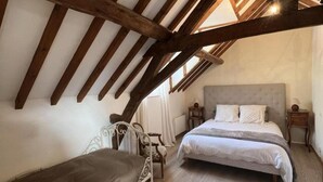 A bedroom with a sloped ceiling, a bed, a chair, and a nightstand. - Charming Home near Loire Castles - Spacious, All-Inclusive, WiFi, Parking, Garden, Sleeps 8 (Vallières-les-Grandes)