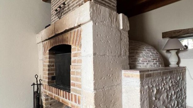 A stone fireplace with a brick arch, a chimney, and a pizza oven. - Charming Home near Loire Castles - Spacious, All-Inclusive, WiFi, Parking, Garden, Sleeps 8 (Vallières-les-Grandes)