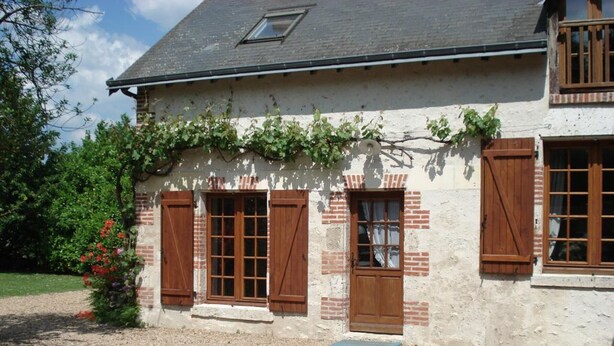 A two-story house with a sloped roof, wooden shutters, and a small window with a shutter. - Family home in Cheverny, enclosed garden, pets allowed, 6 people (Cheverny)