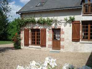 A two-story house with a sloped roof, wooden shutters, and a small window with a shutter. - Family home in Cheverny, enclosed garden, pets allowed, 6 people (Cheverny)