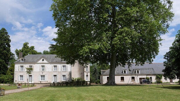 A large, two-story building with a symmetrical facade, a central entrance, and a well-maintained lawn in front. - One-story house with park near Beauval Zoo (Meusnes)