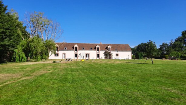 A large, two-story building with a symmetrical facade, multiple windows, and a central entrance. - Family Retreat with Private Pool, Games, and Farm Animals in the Countryside (Danzé)