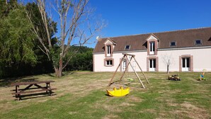 A house with a large lawn, a swing set, and a picnic table. - Family Retreat with Private Pool, Games, and Farm Animals in the Countryside (Danzé)
