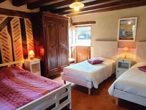 Una stanza con un letto, un armadio, un tavolino e una lampada a parete.
