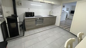 Een kleine keuken met een magnetron, spoelbak en roestvrijstalen apparatuur.
