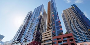 Um conjunto de edifícios altos com estilo arquitetônico moderno, com vários andares e varandas.