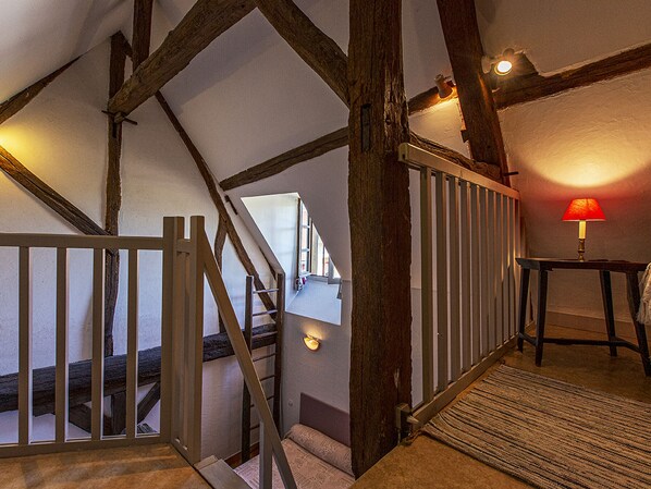 A staircase with wooden beams and a railing, leading to an upper level.