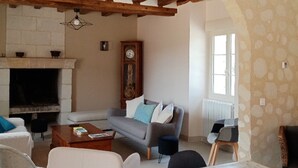 Un salon chaleureux avec une cheminée, un canapé et une table basse.