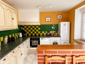 A kitchen with a checkered backsplash, a coffee maker, a toaster, a refrigerator, and a washing machine. - House with private heated pool, pets allowed near Loire castles (La Chapelle-Saint-Martin-en-Plaine)
