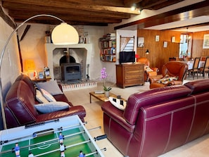 A cozy living room with a fireplace, leather furniture, a foosball table, and a dining area. - Idyllic Family Retreat: Spacious Home with Garden, Kid-Friendly Amenities, and Nearby Attractions (Couddes)