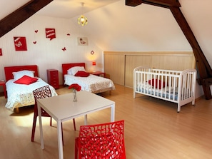 A room with two beds, a crib, a table, and a chair. - Idyllic Family Retreat: Spacious Home with Garden, Kid-Friendly Amenities, and Nearby Attractions (Couddes)