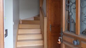 A wooden staircase leading to a room with a wooden door and a decorative glass panel.