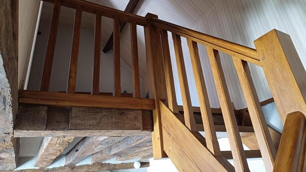 A wooden staircase with a handrail, leading to a room with a sloped ceiling and a white wall. - Cozy house near Blois, pets allowed, parking (Chailles)
