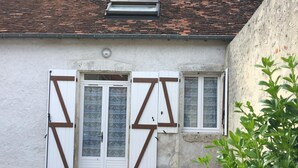 A building with a white facade, a tiled roof, and two windows with shutters. - Cozy house near Blois, pets allowed, parking (Chailles)