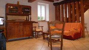 Una sala acogedora con un mueble de madera, un sofá y un sillón.