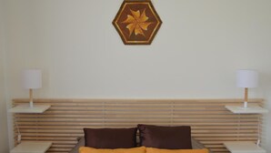 A bedroom with a bed, two bedside tables, a lamp on each table, and a decorative wall piece above the bed. - Spacious house with garden, terrace, and leisure facilities in Pouillé (Pouillé)