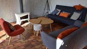 A living room with a sofa, armchairs, a coffee table, a lamp, and a fireplace. - Spacious house with garden, terrace, and leisure facilities in Pouillé (Pouillé)