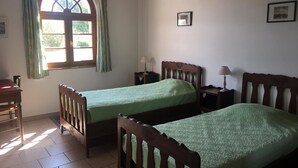 A room with two wooden beds, a window with curtains, a small table, and a chair. - Single-story house with private garden, pets allowed (Villeherviers)