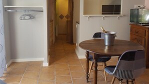 A dining area with a round table, two chairs, a cabinet, and a television on a wooden stand. - Cozy studio with shared garden and parking, ideal for couples facing Pontlevoy Abbey (Pontlevoy)