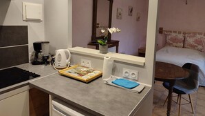 A kitchenette with a coffee maker, a kettle, and a tray with a book and napkins. - Cozy studio with shared garden and parking, ideal for couples facing Pontlevoy Abbey (Pontlevoy)