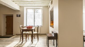 A dining area with a wooden table and chairs, a window with frosted glass, and a view of the outside. - Charming Cottage in Cheverny with Garden and Garden Furniture (Cheverny)
