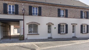 Un bâtiment à deux étages, doté d’une façade en briques et de murs blancs.
