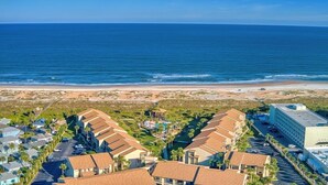 A coastal residential area with beachfront properties, including houses with red roofs and a large building with a flat roof. - Fantastic views from this delightful unit! (St. Augustine)